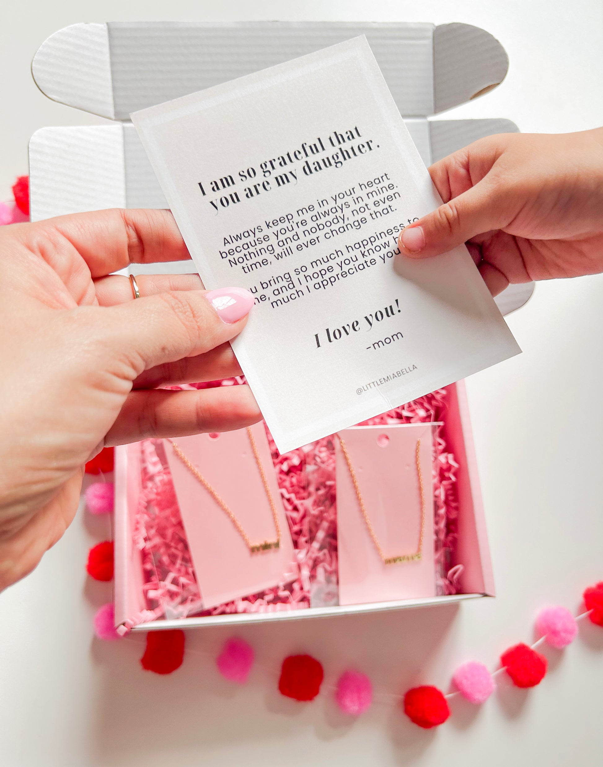 mom handling card to daughter for valentines day