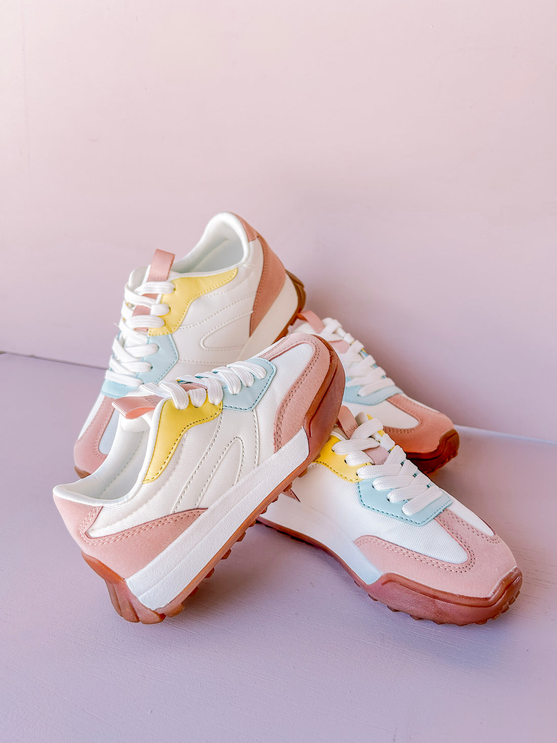 Pair of pastel-colored sneakers on a pink background