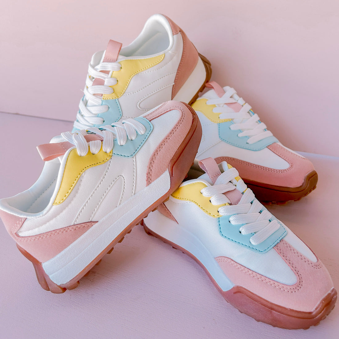 Pair of pastel-colored sneakers on a pink background
