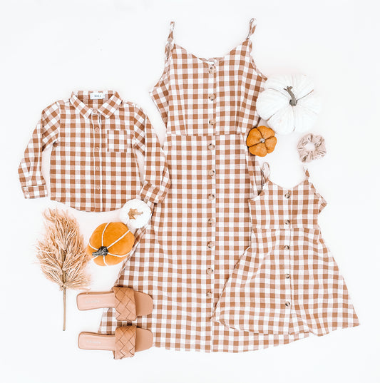 Boy shirt is a long sleeve flannel style with a small pocket on the right- hand side. Adult is a checkered knee length dress same style for girl style.  Dresses are thin strap adjustable.